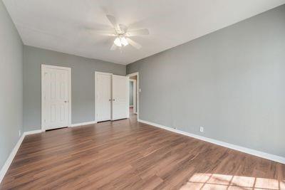 930 Freeman Street Sherman, TX 75092 - Photo 13 of 18 Spacious room featuring wood-finish flooring, light gray walls, and white trim
