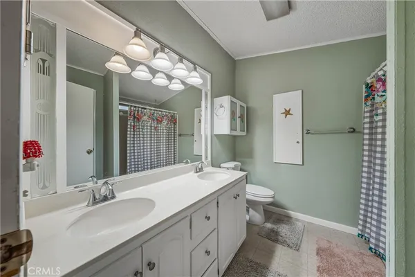 a bathroom with a double vanity sink mirror and toilet