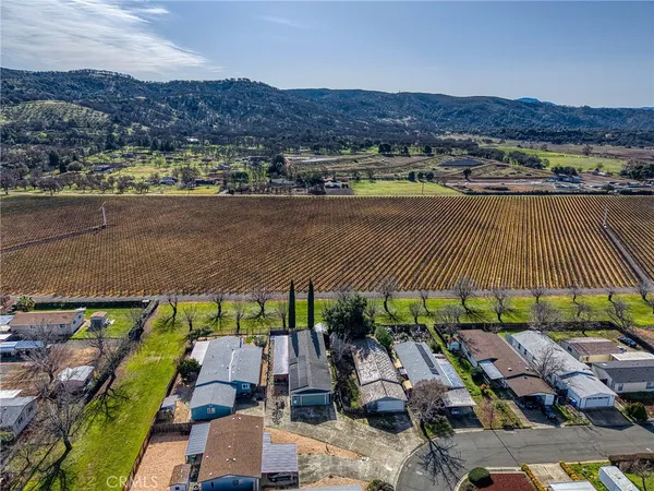 an aerial view of residential houses with outdoor space and lake view