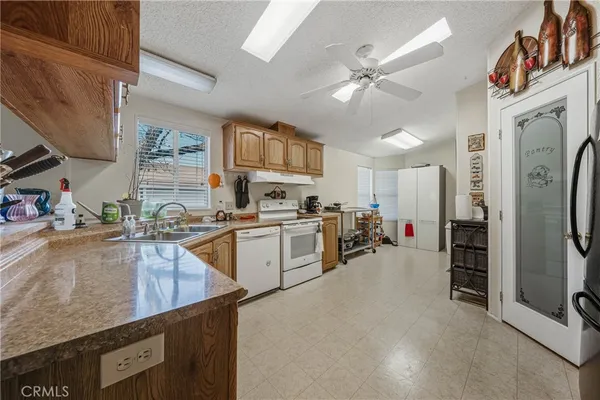 a kitchen with stainless steel appliances granite countertop a refrigerator a stove and a sink