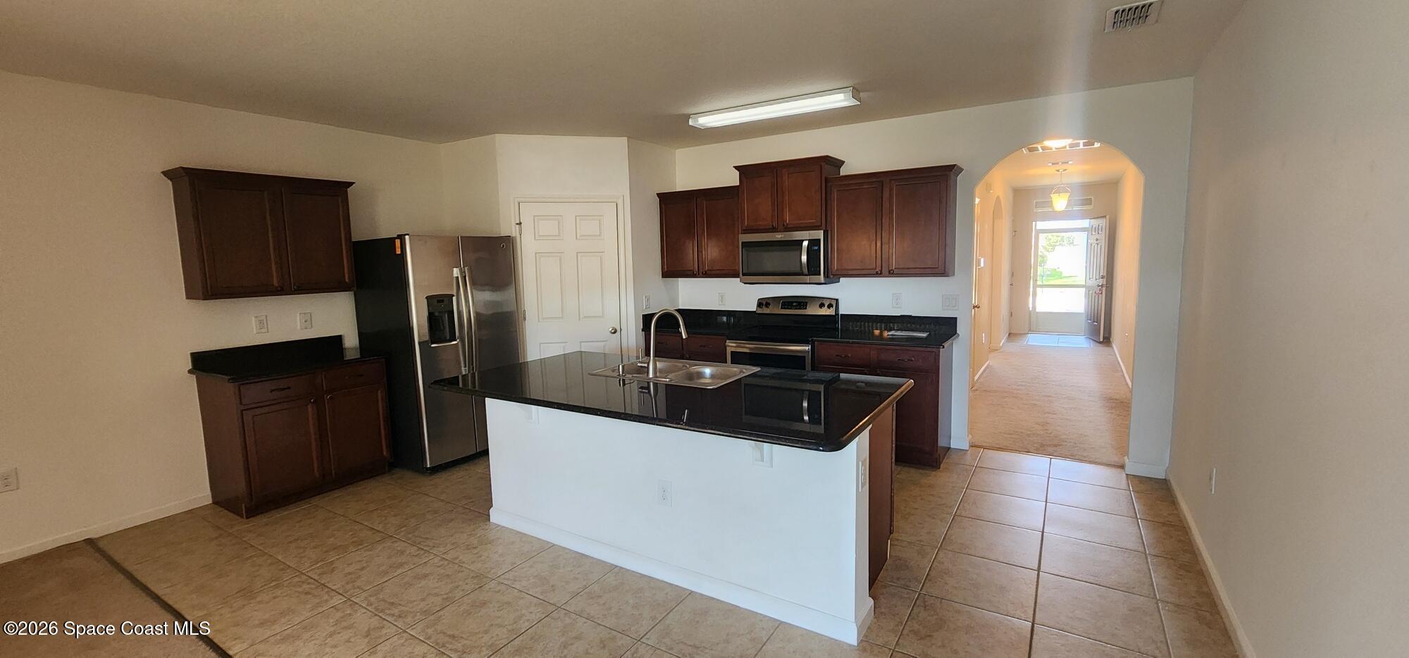 1957 Elkins Point Melbourne, FL 32935 - Photo 13 of 27 a kitchen with stainless steel appliances granite countertop a stove a refrigerator and a sink