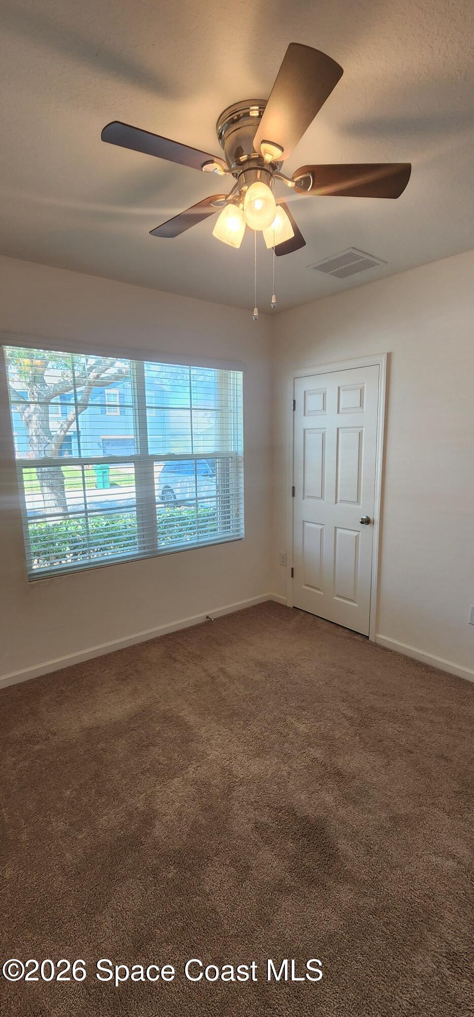1957 Elkins Point Melbourne, FL 32935 - Photo 4 of 27 en empty room with windows and ceiling fan