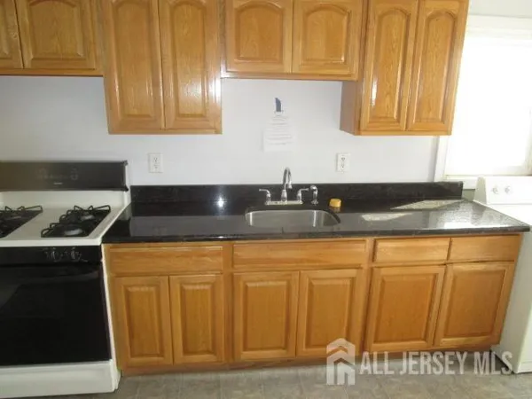a kitchen with granite countertop cabinets and black appliances