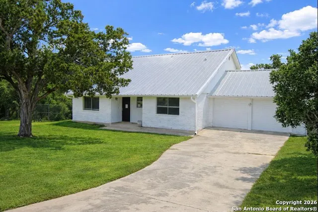 a front view of a house with a garden and yard