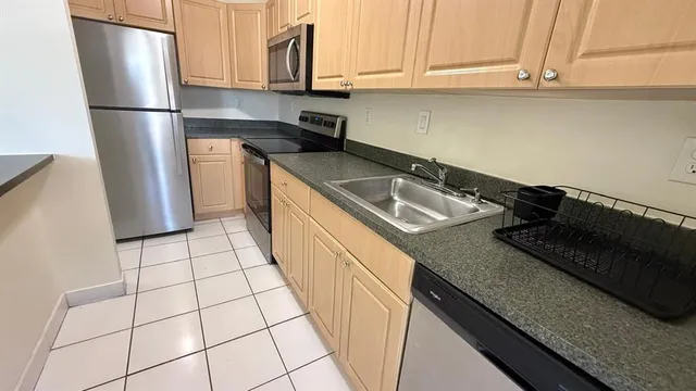 a kitchen with a sink a refrigerator and cabinets