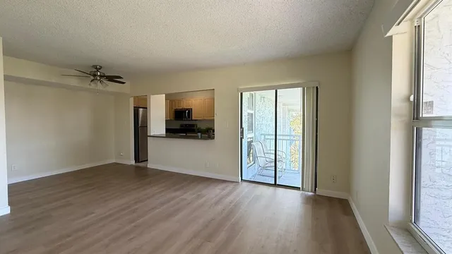 a view of empty room with wooden floor and window