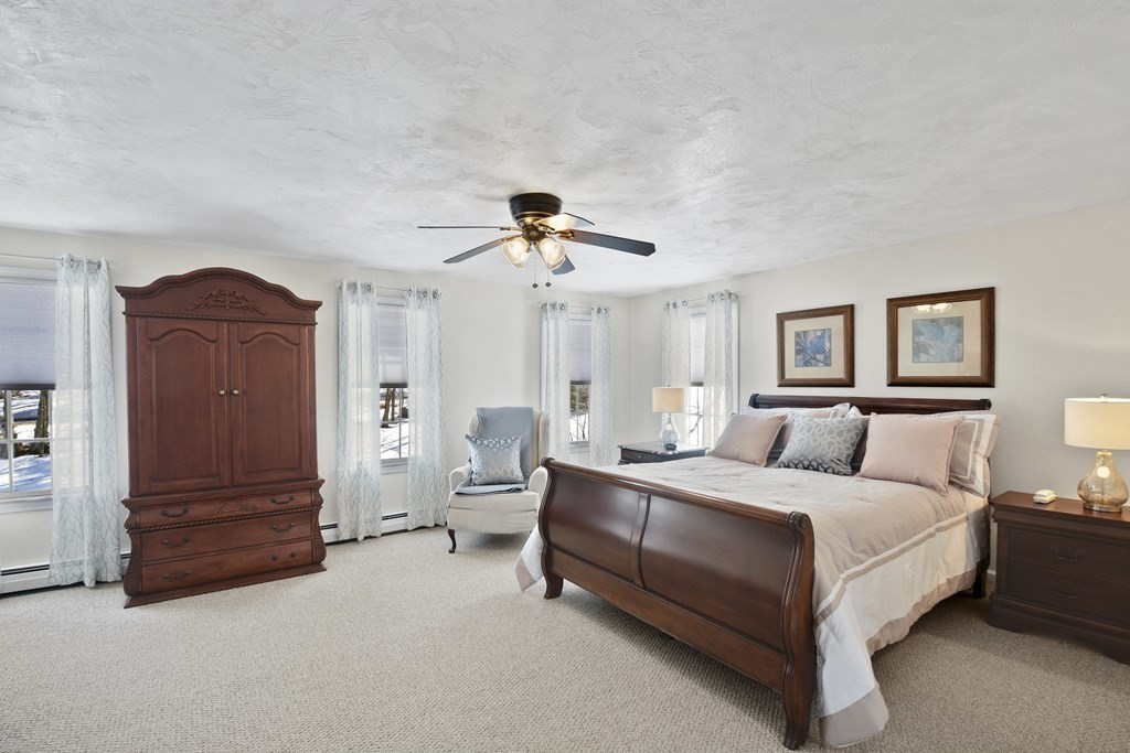 54 Carroll Hill Road Charlton, MA 01507 - Photo 16 of 30 a bedroom with a bed and a chandelier