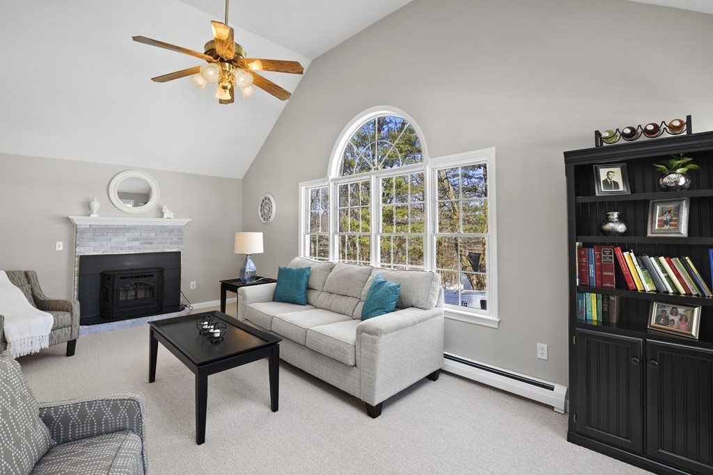 54 Carroll Hill Road Charlton, MA 01507 - Photo 2 of 30 a living room with furniture a bookshelf and a fireplace