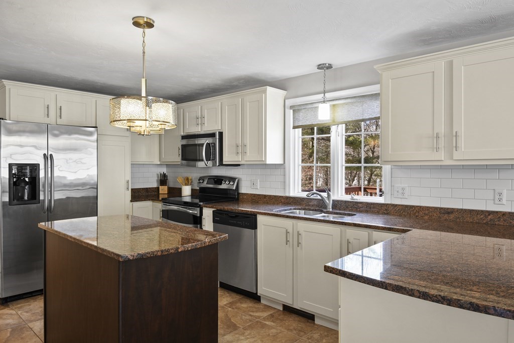 54 Carroll Hill Road Charlton, MA 01507 - Photo 5 of 30 a kitchen with kitchen island granite countertop a sink a counter top space appliances and cabinets