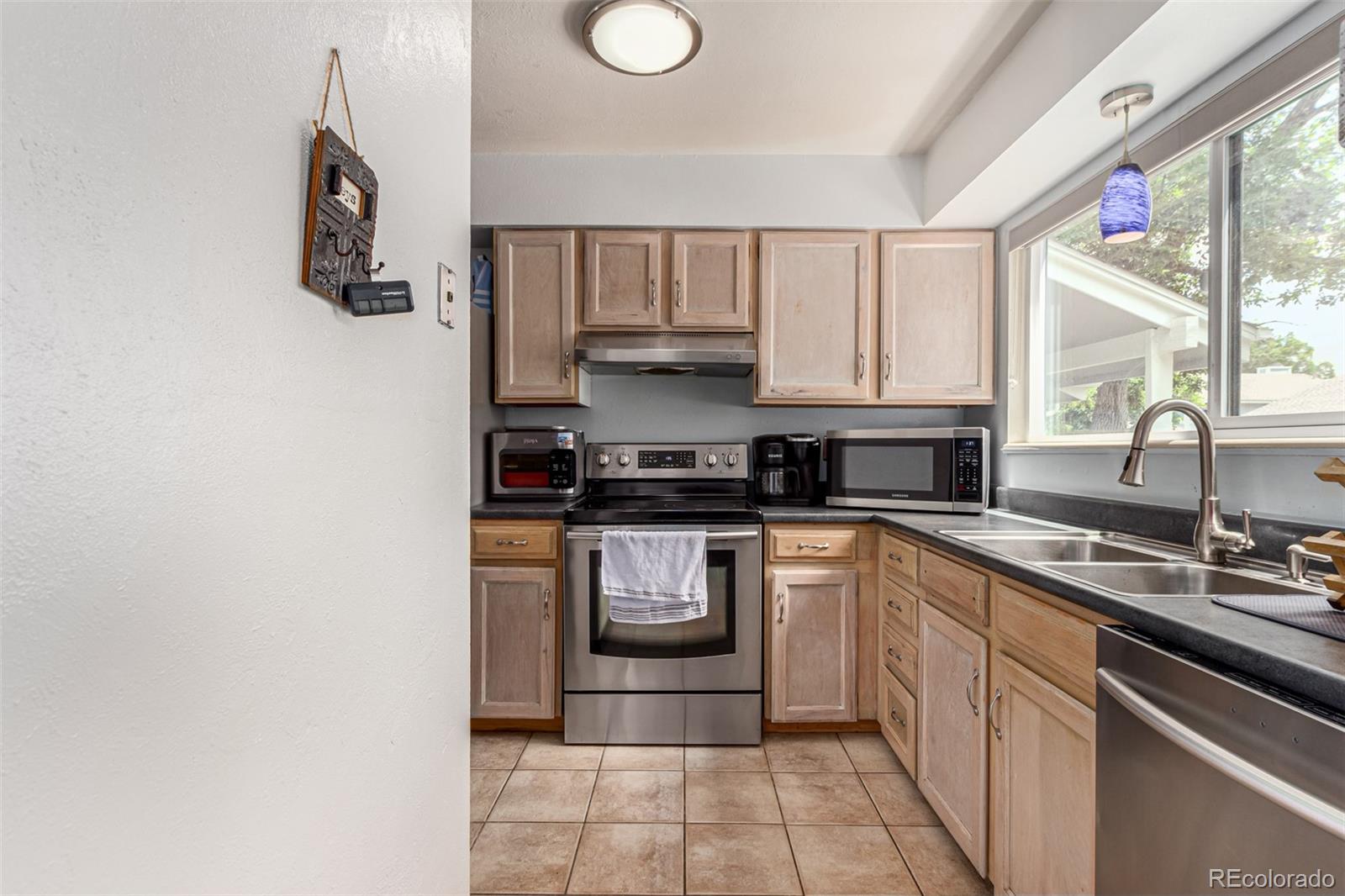 8140 West 90th Avenue Westminster, CO 80021 - Photo 14 of 47 a kitchen with a sink cabinets and window