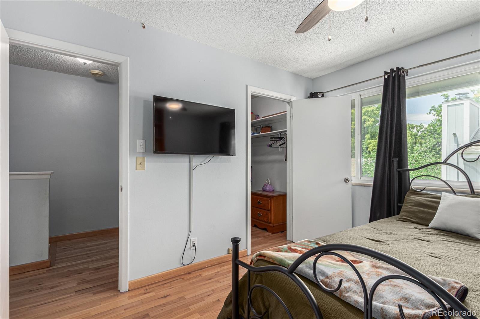 8140 West 90th Avenue Westminster, CO 80021 - Photo 22 of 47 a bedroom with a bed and a flat screen tv