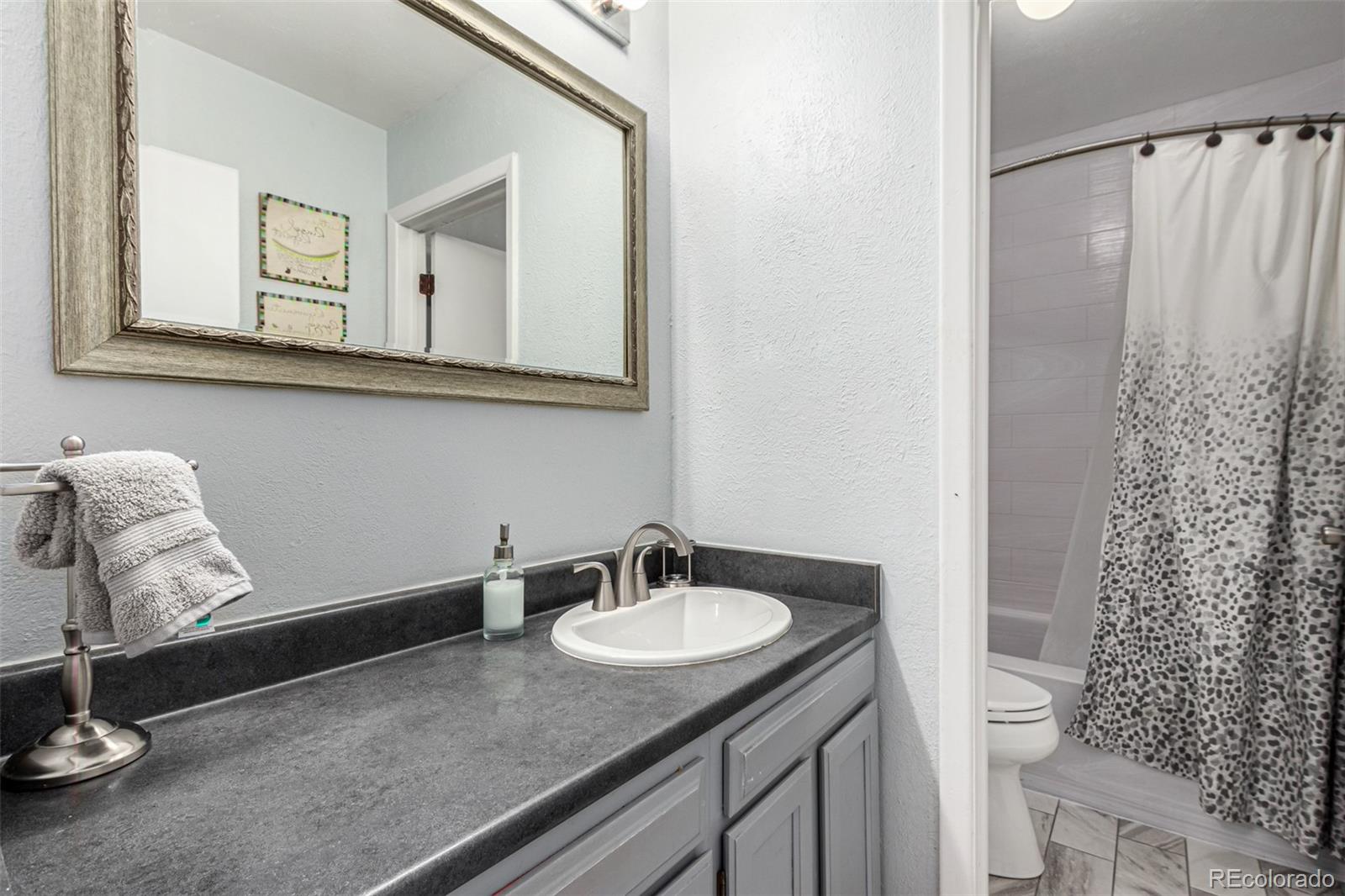 8140 West 90th Avenue Westminster, CO 80021 - Photo 26 of 47 a bathroom with a granite countertop sink and a mirror