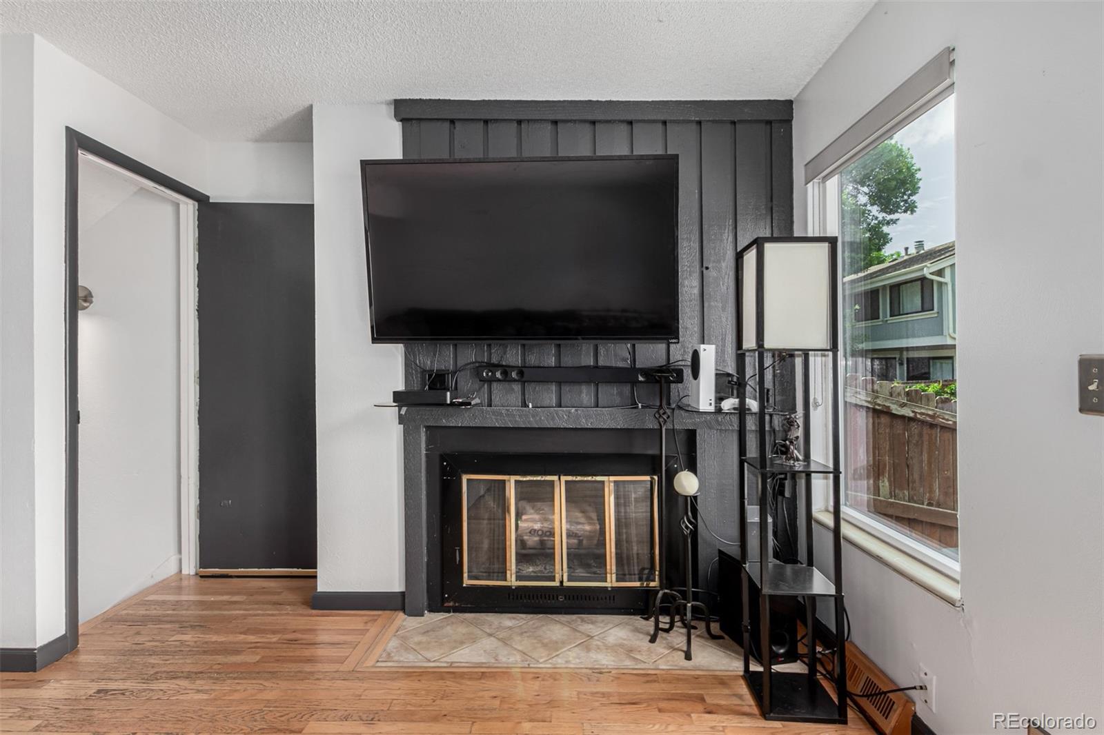 8140 West 90th Avenue Westminster, CO 80021 - Photo 8 of 47 a living room with a flat screen tv and a fireplace