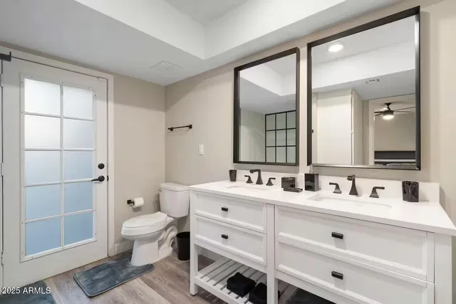 a bathroom with a double vanity sink mirror and toilet