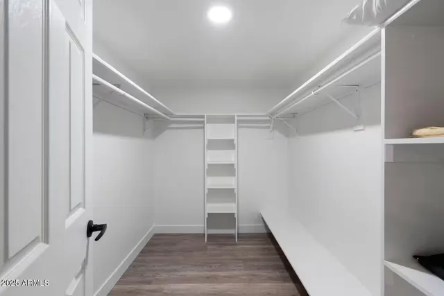 a view of walk in closet with wooden floor