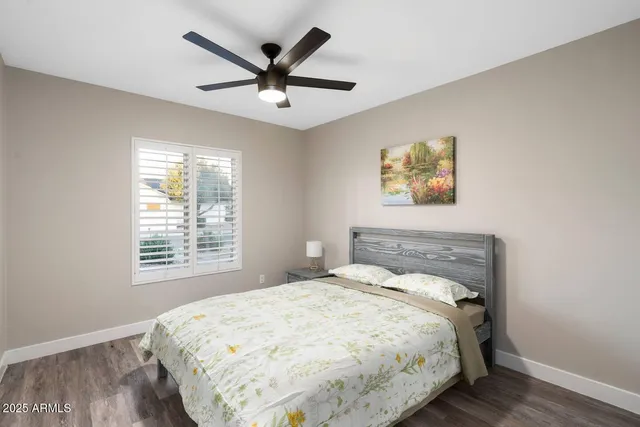 a bedroom with a bed and a painting on the wall