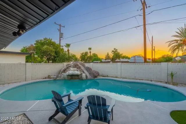 a view of a swimming pool with a chair and tables