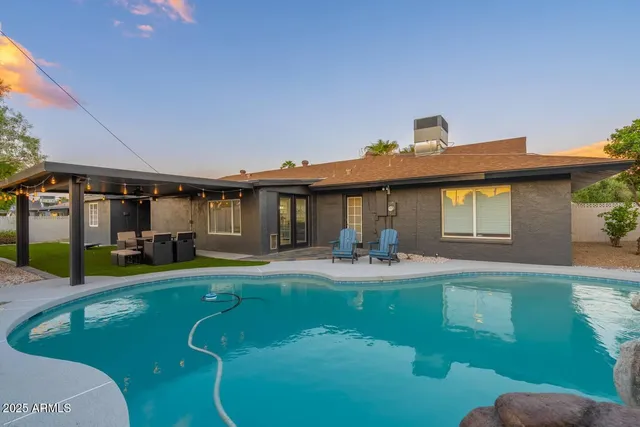 a view of a house with swimming pool and sitting area