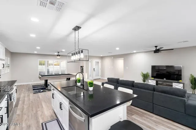 a living room with furniture a chandelier and a flat screen tv