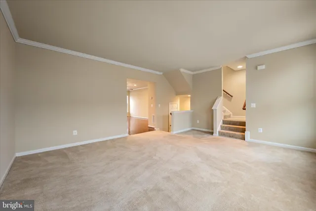 a view of an empty room with stairs and a window