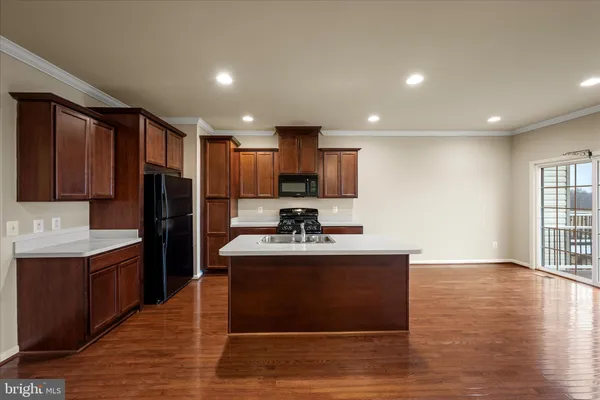 a view of kitchen with sink microwave and refrigerator