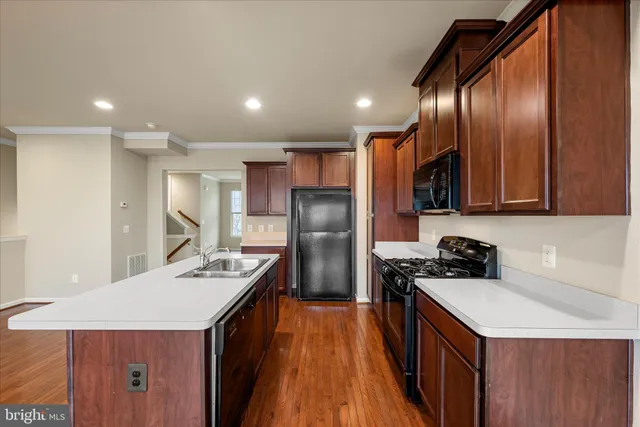 a kitchen with stainless steel appliances a sink a stove a refrigerator and cabinets
