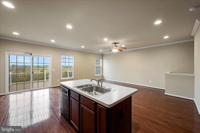 a kitchen with a sink and wooden floor
