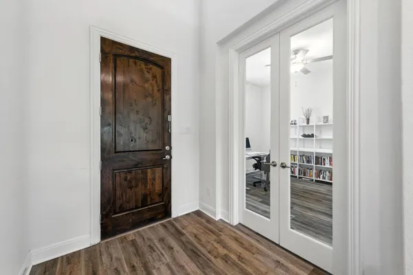 a view of a hallway with wooden floor and entryway