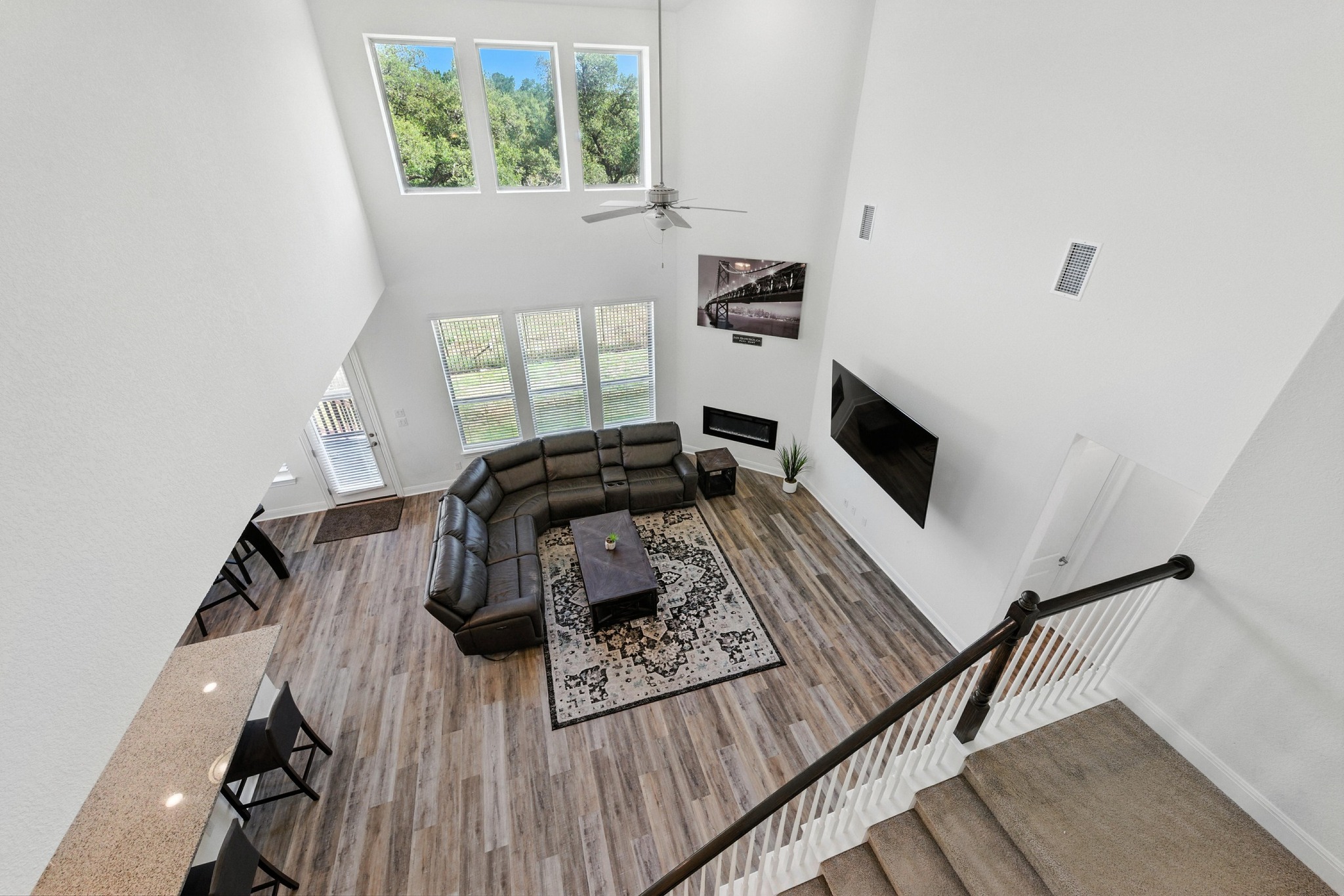 216 Tovas Secret Cove Georgetown, TX 78628 - Photo 31 of 39 Living room with plenty of natural light, a high ceiling, a ceiling fan, wood finished floors, and a glass covered fireplace