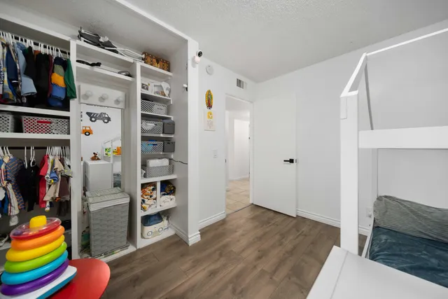 a view of walk in closet with clothes and shoes