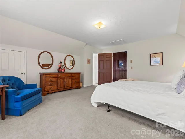 a spacious bedroom with a bed and dresser