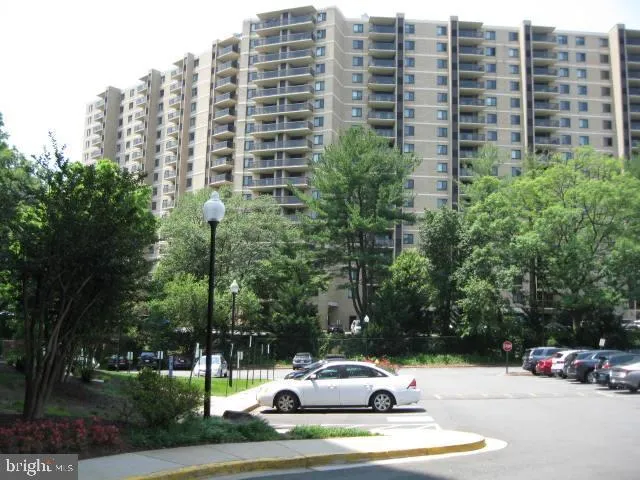 a view of a buildings and car parked on the roadside