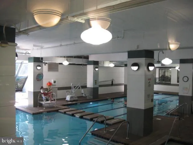 a room with lots of white furniture and a chandelier