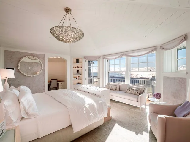 a bedroom with a large bed and ceiling fan