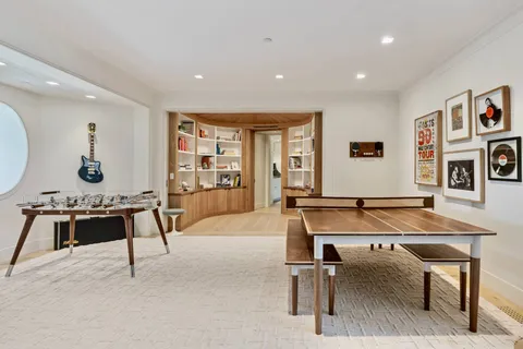 a living room with table tennis and air hockey table