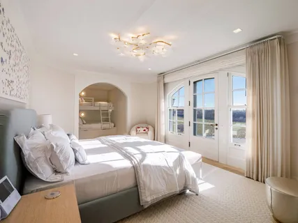 a bedroom with a large bed and a chandelier