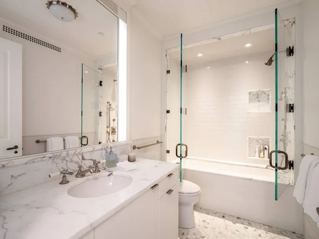 a bathroom with a tub sink and mirror