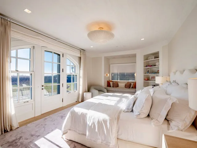 a bedroom with a large bed and a large window