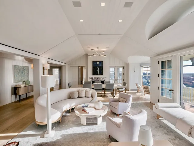 a living room with couches and a view of kitchen