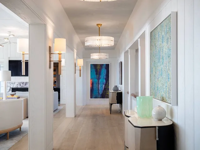 a view of a hallway with furniture and a chandelier