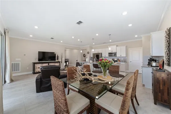 a living room with furniture a flat screen tv and kitchen view