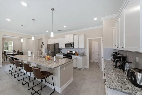 a kitchen with stainless steel appliances kitchen island granite countertop a sink and cabinets