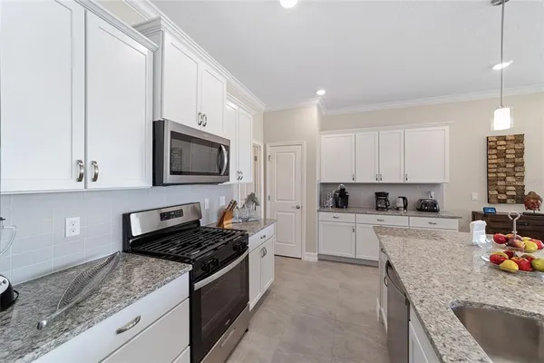 a kitchen with granite countertop a stove sink and cabinets