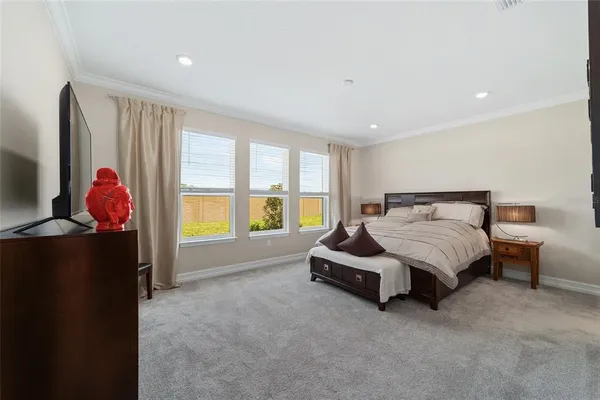 a spacious bedroom with a bed and a dresser next to a window