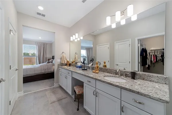 a spacious bathroom with a granite countertop sink a toilet and a mirror
