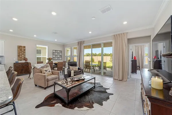 a living room with furniture a flat screen tv and a large window