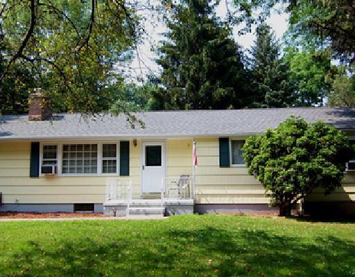 a front view of a house with a yard and trees