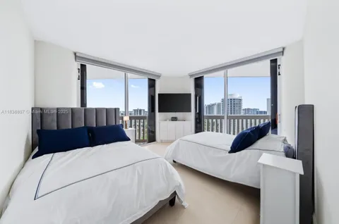 a bedroom with a bed window and a flat tv screen