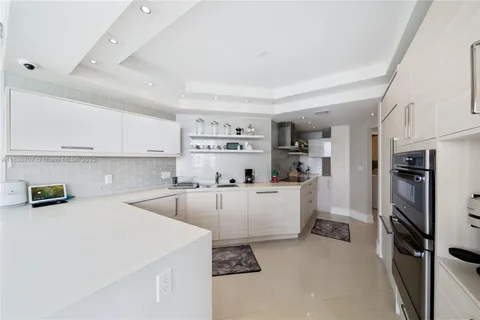 a kitchen that has a lot of cabinets a sink and appliances in it
