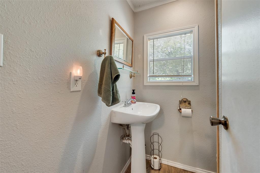 233 East High Street Wills Point, TX 75169 - Photo 32 of 40 Bathroom featuring ornamental molding, a textured wall, and wood finished floors